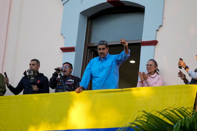 El presidente Nicolás Maduro hace gestos a sus seguidores durante un discurso desde un balcón del palacio presidencial en defensa de su reelección, en Caracas, Venezuela, el martes 30 de julio de 2024. (AP Foto/Fernando Vergara)