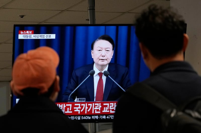 Personas ven un televisor con la imagen del presidente surcoreano Yoon Suk Yeol en una terminal de autobuses en Seúl, Corea del Sur, el martes 3 de diciembre de 2024. (AP Foto/Ahn Young-joon)