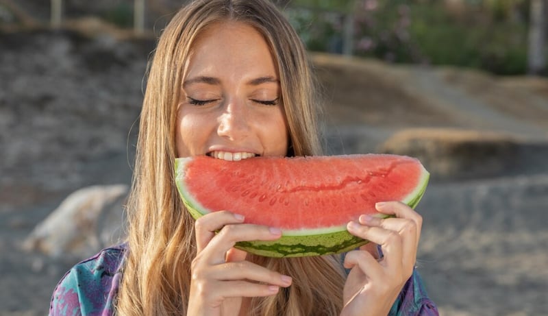 Vista frontal de la hermosa mujer comiendo sandía